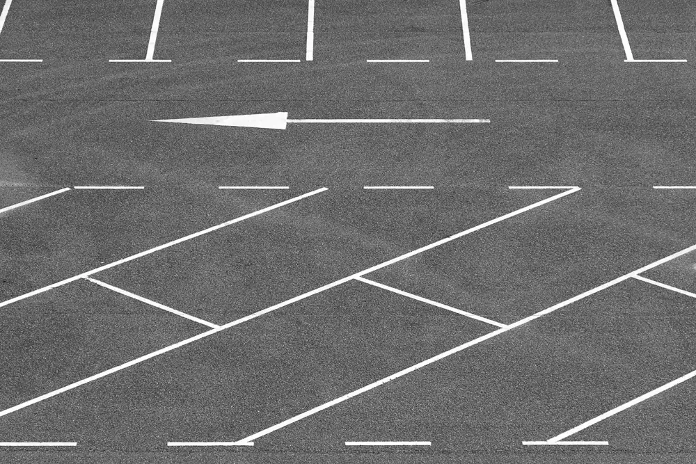 Painted directional arrow and parking lines on asphalt