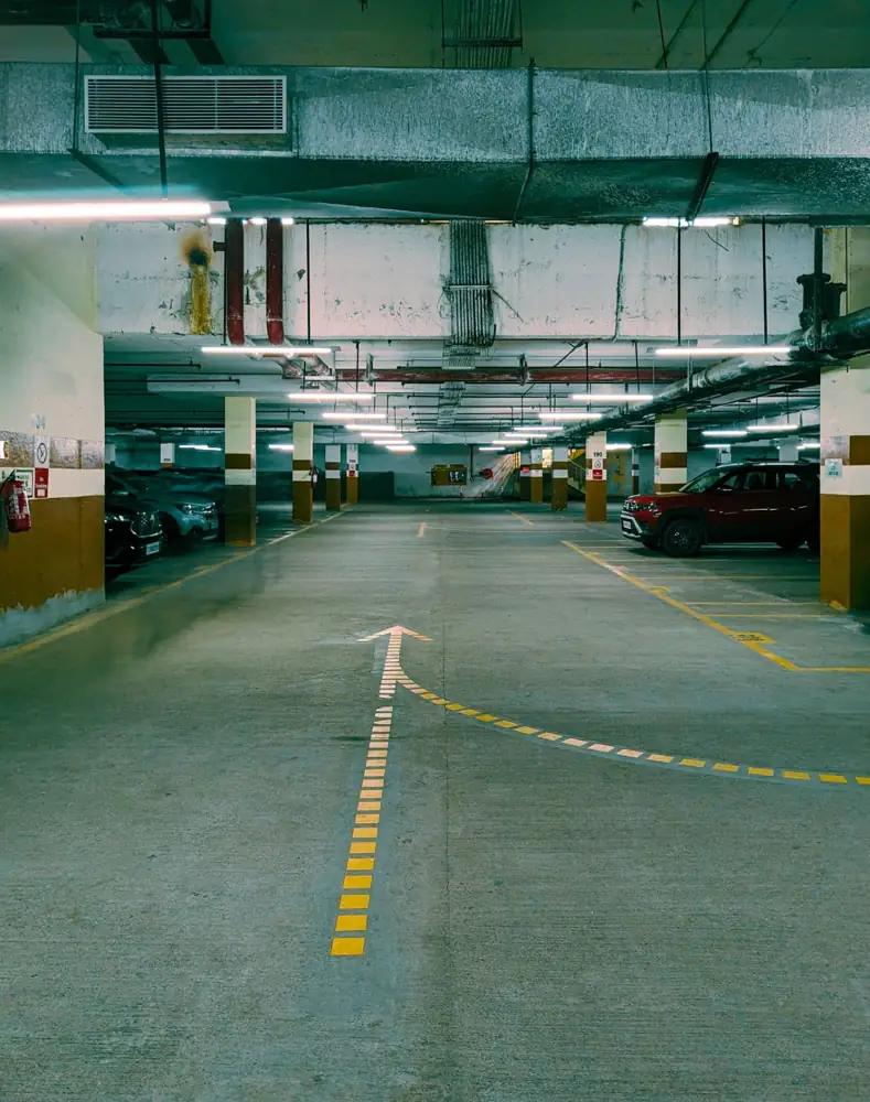 Yellow center line and arrow guiding traffic through a parking garage