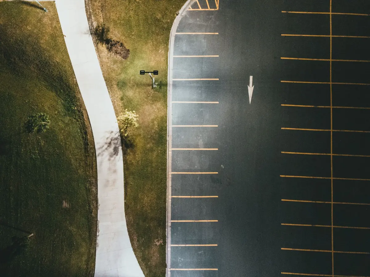Aerial view of a freshly striped parking lot beside a walkway