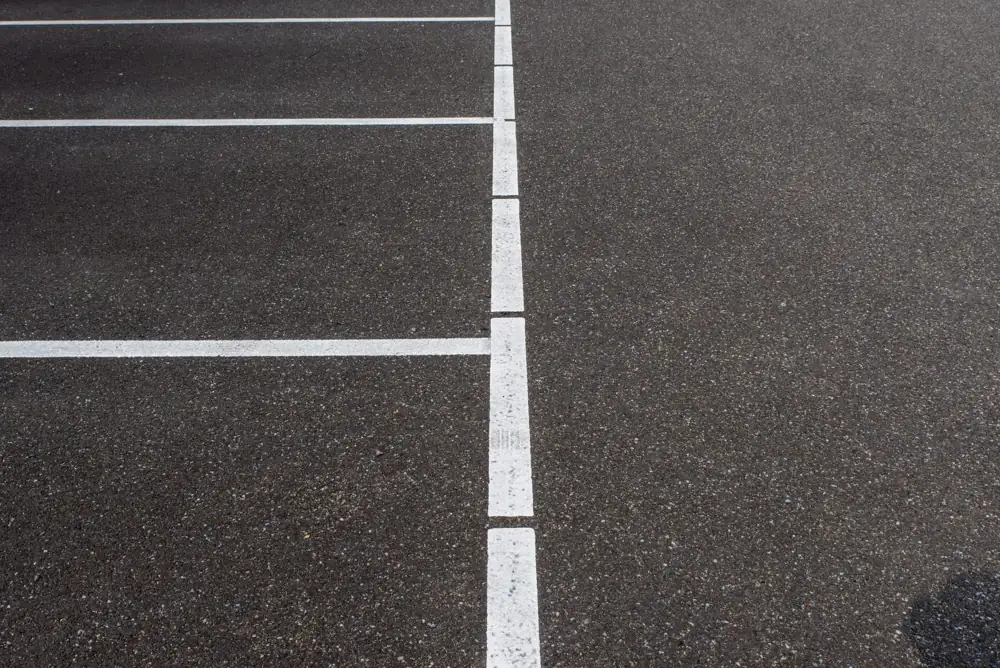 Fresh white parking space lines on dark asphalt